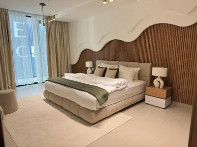 a bedroom with a large bed with a large headboard at Binghatti Galaxy 2 in Dubai
