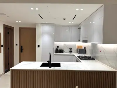 a kitchen with white counters and a counter top at Binghatti Galaxy 2 in Dubai