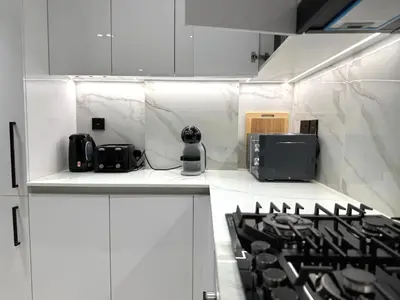 a kitchen with white cabinets and a stove top oven at Binghatti Galaxy 2 in Dubai