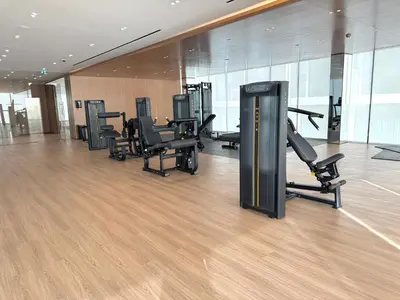 a gym with a row of treadmills and exercise equipment at Binghatti Galaxy 2 in Dubai
