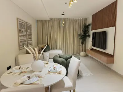a living room with a white table and chairs at Binghatti Galaxy 2 in Dubai