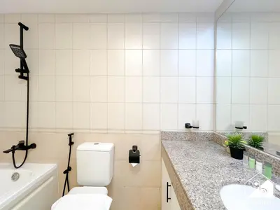 a bathroom with a toilet and a sink and a tub at Stylish JVC Duplex l Gym, Pool & Parking in Dubai