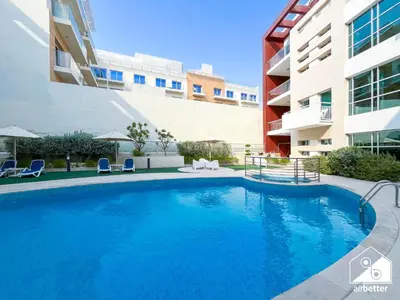 a swimming pool in front of a building at Stylish JVC Duplex l Gym, Pool & Parking in Dubai
