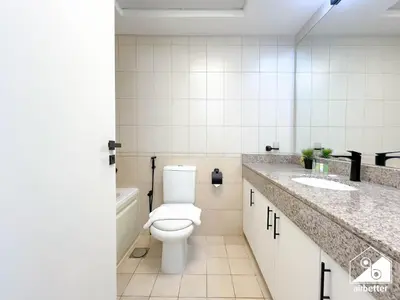 a white bathroom with a toilet and a sink at Urban Duplex Hideaway l Gym, Pool & Balcony in Dubai