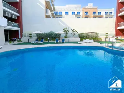 a large blue swimming pool in front of a building at Urban Duplex Hideaway l Gym, Pool & Balcony in Dubai