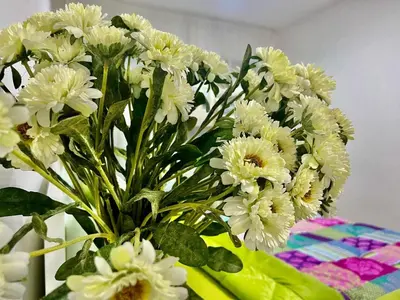 a bouquet of white flowers in a vase on a table at Sleep 6 Mina Road in Dubai