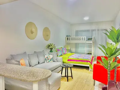 a living room with a couch and a bed at Sleep 6 Mina Road in Dubai