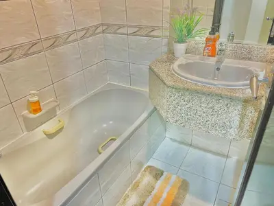 a bathroom with a sink and a bath tub at Sleep 6 Mina Road in Dubai