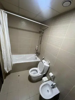 a bathroom with a toilet and a tub and a sink at Cozy Studio with Sofa bed beside DMCC Metro & Dubai Marina in Dubai
