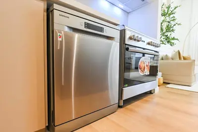 a stainless steel refrigerator and oven in a kitchen at GV Holiday Homes DXB - Cozy 2BR Apartment in Town Square Dubai in Dubai