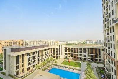 an aerial view of a building with a pool at GV Holiday Homes DXB - Cozy 2BR Apartment in Town Square Dubai in Dubai
