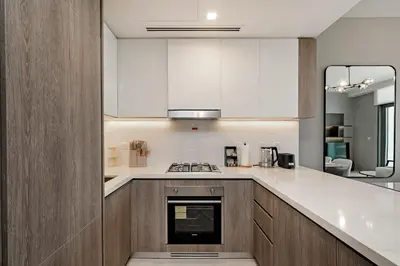 a kitchen with white cabinets and a stove top oven at Exciting 1BR apartment Liv Marina in JBR in Dubai