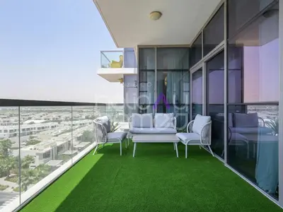 a balcony with chairs and a green carpet at Modern 2BR Gem Full Golf Views & Pool in Dubai