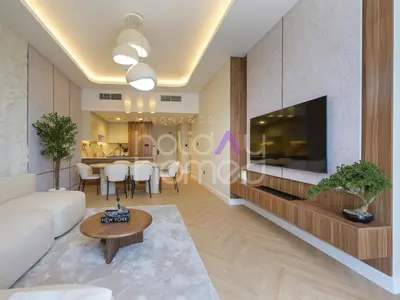 a living room with a couch and a tv at Modern 2BR Gem Full Golf Views & Pool in Dubai