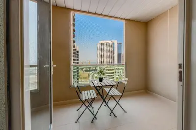 a balcony with a table and chairs and a window at Spacious 1BR in Great Location, Manchester Tower, Dubai Marina in Dubai