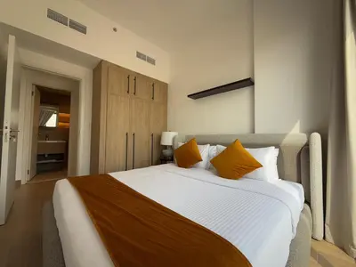 a bedroom with a large bed with orange pillows at 1 Bedroom Apartment in Liva by the S Holiday Homes in Dubai