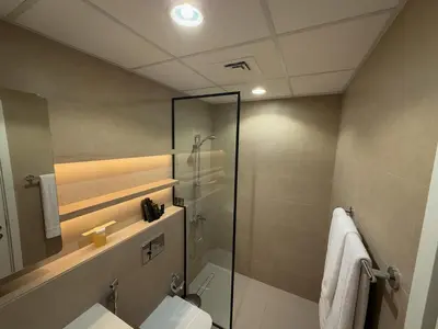 a bathroom with a glass shower and a toilet at 1 Bedroom Apartment in Liva by the S Holiday Homes in Dubai