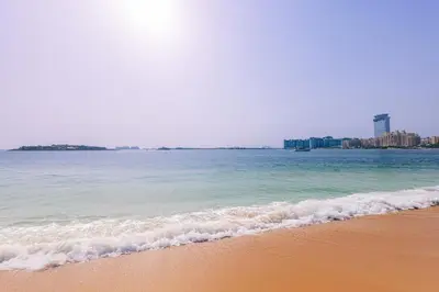 a beach with the ocean and buildings in the background at Sea Breeze apartment in Grand Bleu - private Beach in Dubai