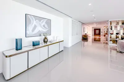 a white living room with a long white counter at Sea Breeze apartment in Grand Bleu - private Beach in Dubai