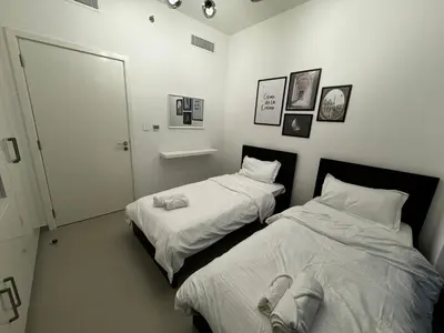 two beds sitting next to each other in a room at 2min Walk to Dubai Mall - 2BR - Infinity Pool & Gym - Burj Khalifa in Dubai