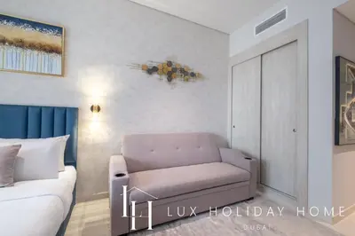 a living room with a couch and a bed at LUX The Seven Res Palm Studio in Dubai
