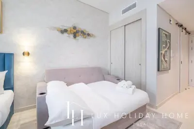 a living room with a couch and a bed at LUX The Seven Res Palm Studio in Dubai