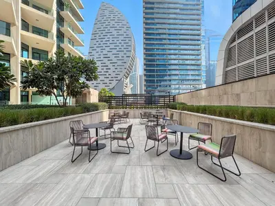 a patio with tables and chairs and buildings at BLVD - Missoni Canal View - Walk to Dubai Mall in Dubai
