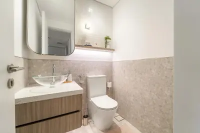 a bathroom with a toilet and a sink and a mirror at 1BR Luxury Stay in Sobha Hartland in Dubai