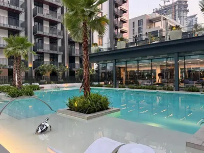 a swimming pool with a penguin in front of a building at 1BR Luxury Stay in Sobha Hartland in Dubai