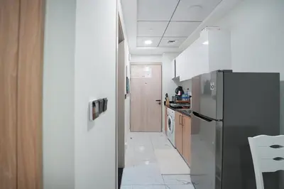 a kitchen with a stainless steel refrigerator and wooden cabinets at EasyGo- Comfy, near metro, Easy Access to City Roads in Dubai