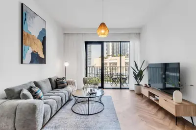 a living room with a couch and a tv at Relax & Unwind with Dubai Creek Vibes in Dubai