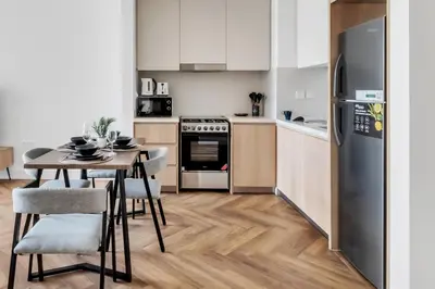 a kitchen with a table and a refrigerator at Relax & Unwind with Dubai Creek Vibes in Dubai