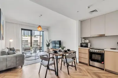a kitchen and living room with a table and chairs at Relax & Unwind with Dubai Creek Vibes in Dubai