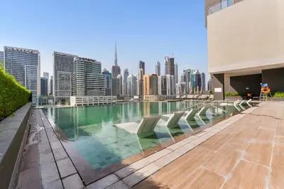 a swimming pool on the roof of a building with a city skyline at Waves - Stylish Studio Near Downtown Dubai in Dubai