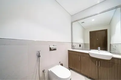 a bathroom with a sink and a toilet and a mirror at Prestige Jumeirah 4BR Villa with Rooftop and Private Garden in Dubai