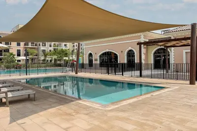 a swimming pool with a large umbrella over it at Prestige Jumeirah 4BR Villa with Rooftop and Private Garden in Dubai