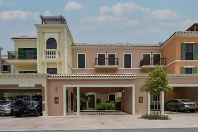 a large house with cars parked in a parking lot at Prestige Jumeirah 4BR Villa with Rooftop and Private Garden in Dubai