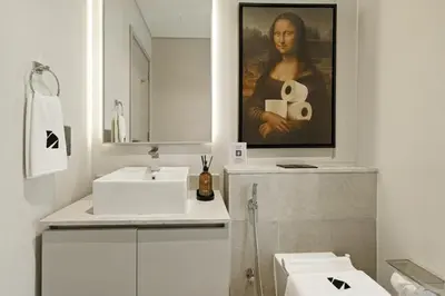 a bathroom with a sink and a painting of a woman at New 2.5 BR Villa With PS5 and Garden Near Dubai Mall in Dubai