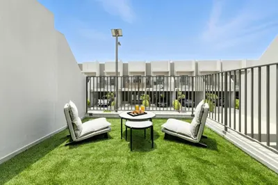a balcony with two chairs and a table and grass at New 2.5 BR Villa With PS5 and Garden Near Dubai Mall in Dubai