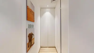 a hallway with a white wall and a door at Iris Blue - Colourful One Bedroom in The Marina in Dubai