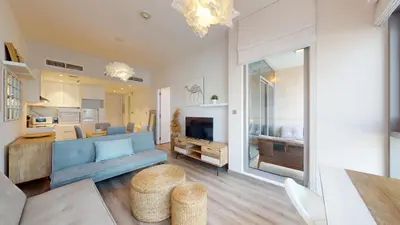 a living room with a blue couch and a kitchen at Iris Blue - Colourful One Bedroom in The Marina in Dubai