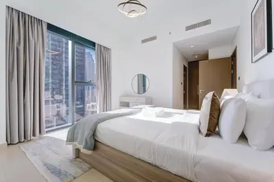 a bedroom with a large bed with a large window at Vacationer l Vibrant 2 Bedroom l Pool with Burj Khalifa View in Dubai