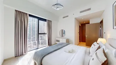 a bedroom with a white bed and a large window at Vacationer l Vibrant 2 Bedroom l Pool with Burj Khalifa View in Dubai