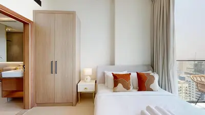 a bedroom with a white bed and a sink at Binghatti Tulip - High Rise Upgraded Studio in JVC in Dubai