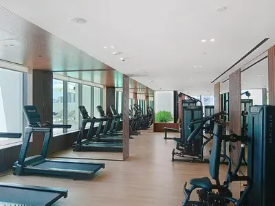 a gym with a row of treadmills in a building at Binghatti Tulip - High Rise Upgraded Studio in JVC in Dubai