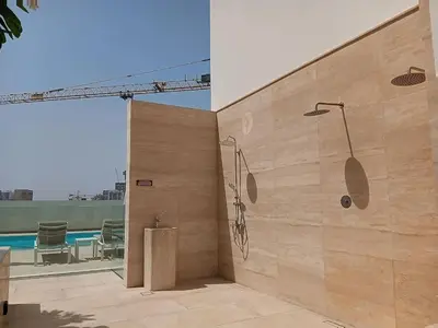 a bathroom with a shower and a pool at Binghatti Tulip - High Rise Upgraded Studio in JVC in Dubai