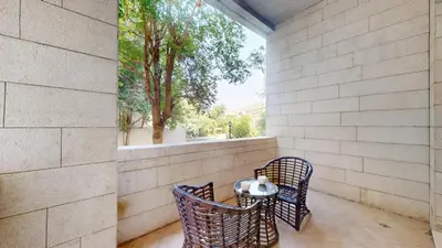 an outdoor patio with two chairs and a table at Sherlock House 2 - Peaceful One Bed in Motor City in Dubai