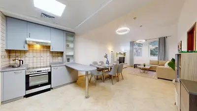 a kitchen and living room with a table and chairs at Sherlock House 2 - Peaceful One Bed in Motor City in Dubai