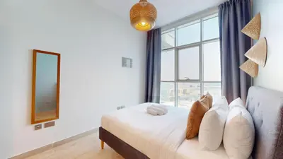 a bedroom with a bed with a large window at Studio One - Sleek One Bedroom with City View in Dubai