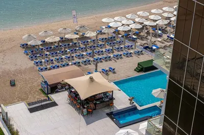 an overhead view of a beach with a pool and umbrellas at Palm Jumeirah Luxury Apt Direct Beach Access & Views in Dubai